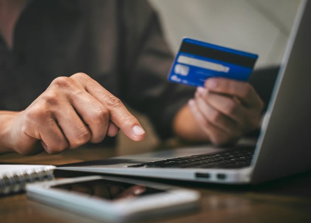 a person holding a credit card and pointing at a credit card