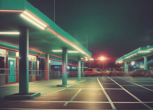 A darkly lit scene featuring a ceiling-mounted light fixture and a sensor device. The light fixture emits a soft white glow, while the sensor has a small green light. The background is mostly in shadow, adding a sense of depth and mystery.