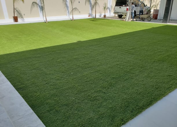 Césped sintético verde y duradero instalado en un patio trasero en Guadalajara