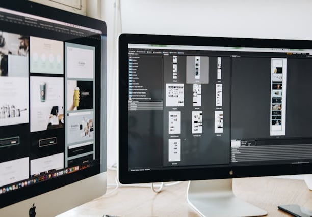 Two monitors displaying mockups for a website design