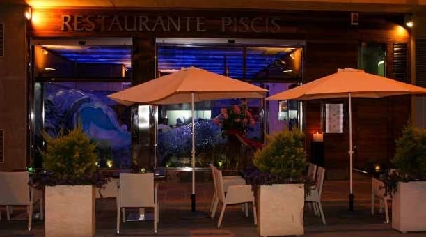 a restaurant with tables and umbrellas outside