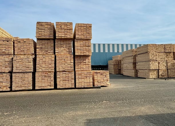 a bunch of stacks of bricks in a warehouse yard