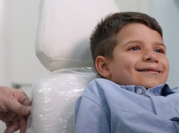 a young boy sitting in a chair in a hospital