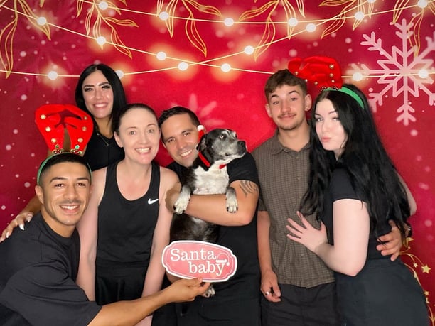 Carly from SweetAz Co. with her two daughters and dog Phoenix in the Christmas-themed open air photo booth in Redlands.