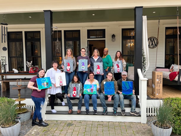 a group of people holding up their paintings