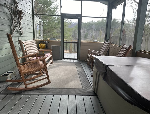 Screened in porch with rocking chairs and 2 person hot tub. 