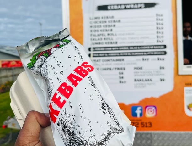 a person holding a bag of kebab
