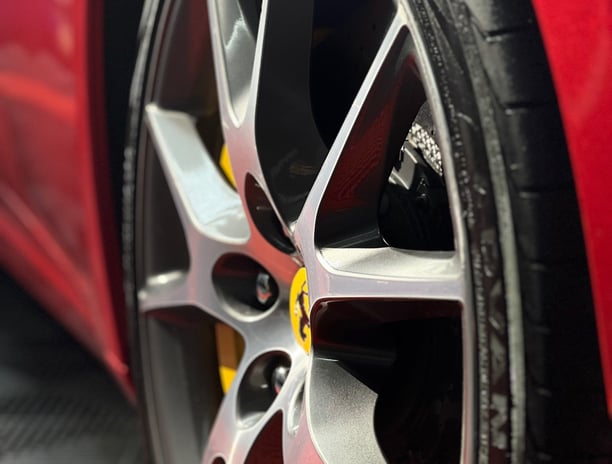 a red car with a yellow wheel and a black tire