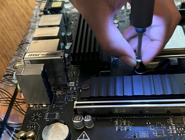 Child attaching a SSD to a motherboard - STEM