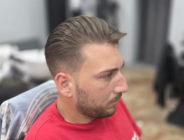 "Taglio classico con sfumatura bassa e ciuffo pettinato all'indietro