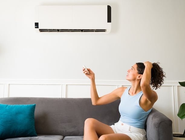 a woman sitting on a couch with a remote control