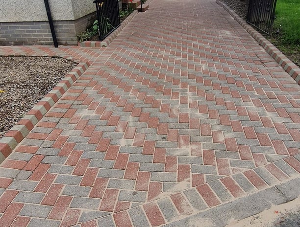 a driveway with a brick paved driveway and a driveway