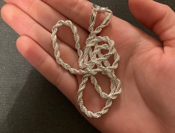 a person holding a silver chainmail with a silver chain link