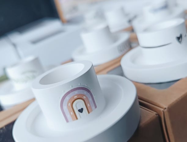 eine Auswahl an handgefertigten, weißen Kerzenhaltern mit individuellen Verziehrungen