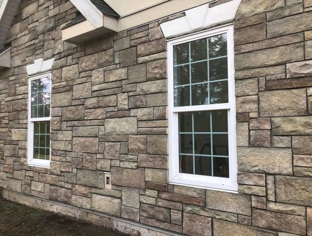 a house with a brick wall and windows