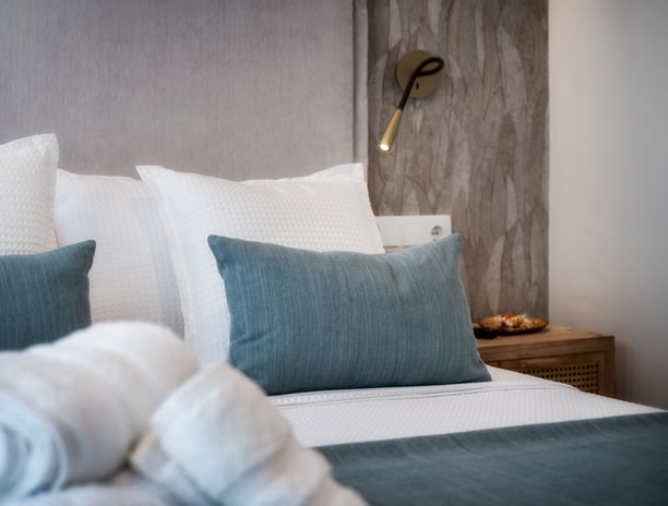 Una cama con una manta y almohadas encima