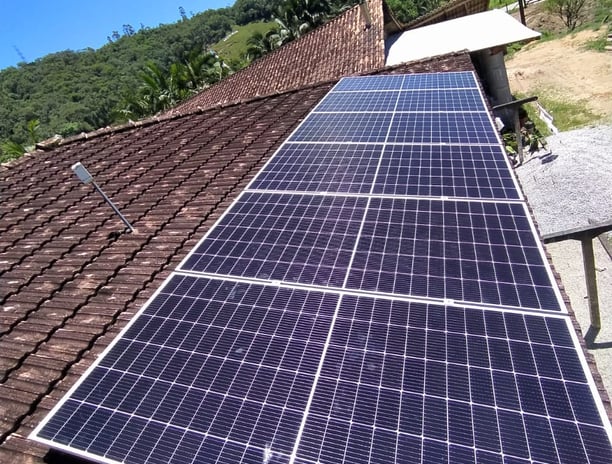 Telhado residencial com painéis solares instalados, captando energia limpa e sustentável.