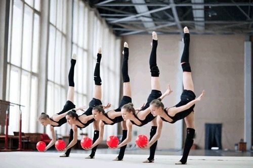 Rhythmic gymnasts is performing a routine with five balls