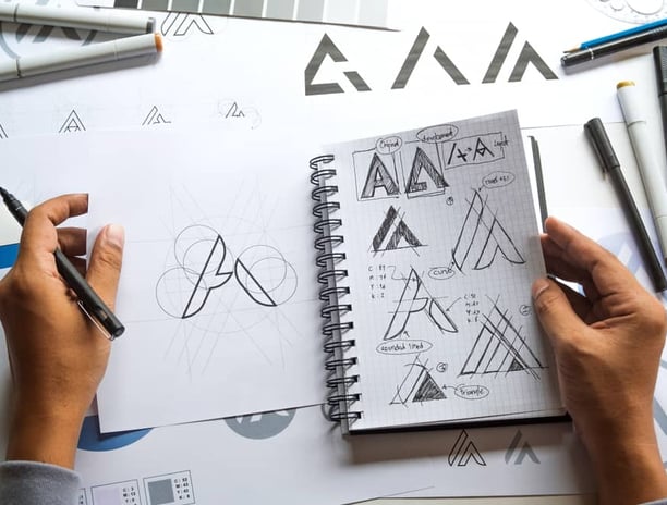 Designer sketching logo concepts at Desynco Studio, showcasing creative design development.