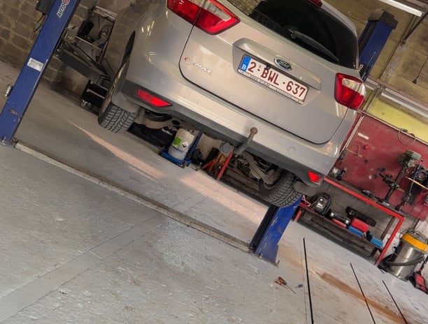 a car is parked in a garage with a car underneath it