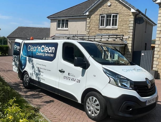 exterior cleaning company van with logo on the side of a driveway