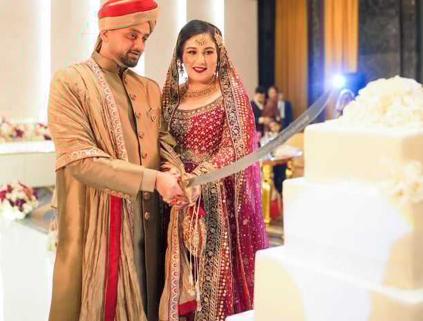 a man and woman are cutting into a wedding cake