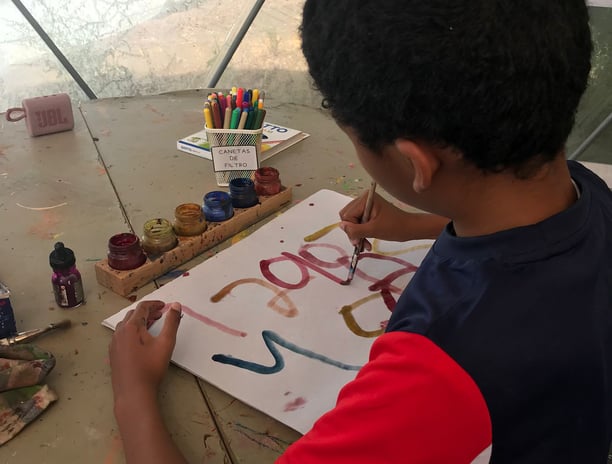boy painting numbers on paper