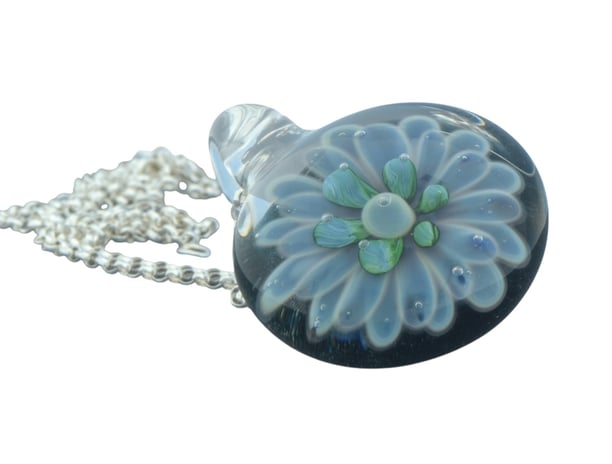a glass pendant necklace with a flower on it