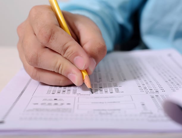 student filling in answers on a scantron during an ACT test after preparing with Benny DePoyster