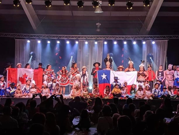 a group of people standing on a stage with a Chilean flag