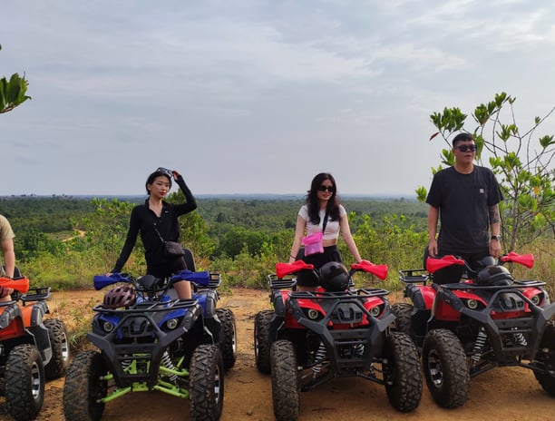 a group of people standing around four wheeler quad atvs