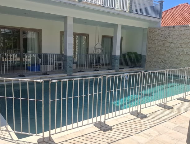 a pool with a fenced in area with a grill