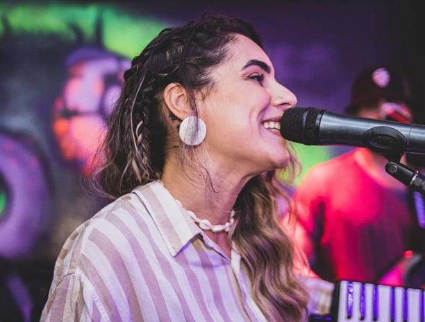 woman singing into microphone on stage