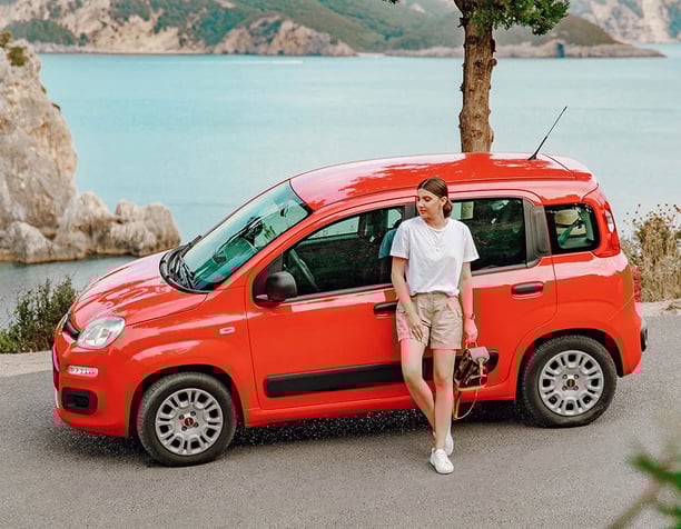 a woman standing next to a red van
