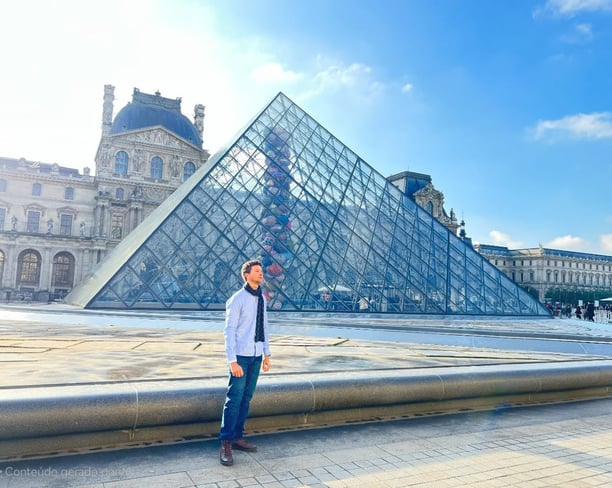 homem em pé em frente a parte externa do museu do Louvre em Paris