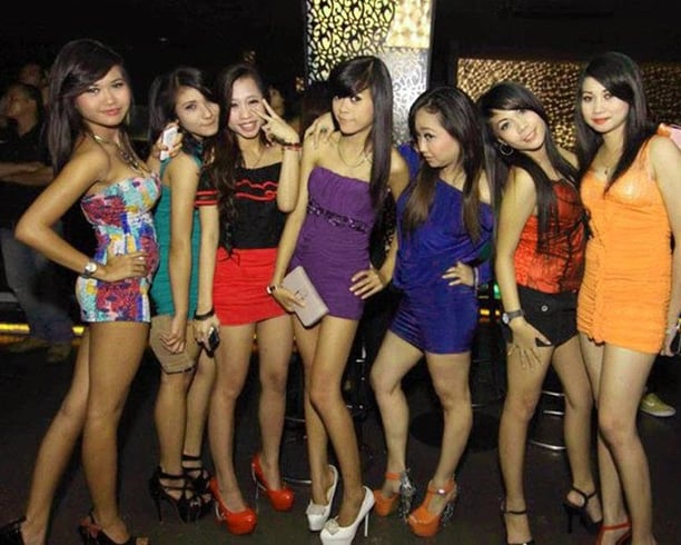 a group of young women standing in front of a bar