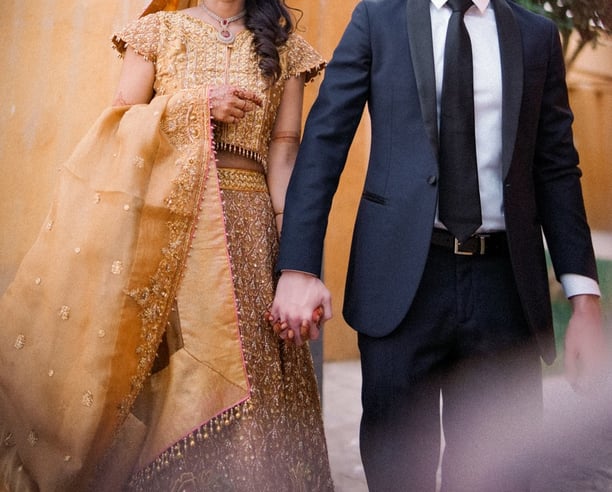 a man and woman holding hands and walking through a doorway