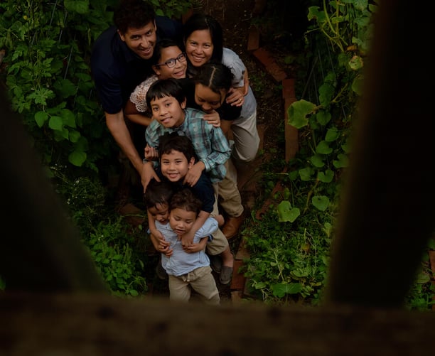 All eight members of the Schauder family posing in their garden. 