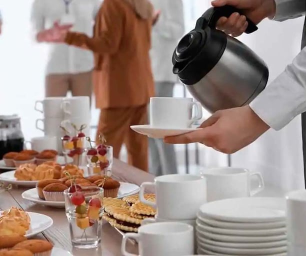 a person is pouring tea into a cup of coffee