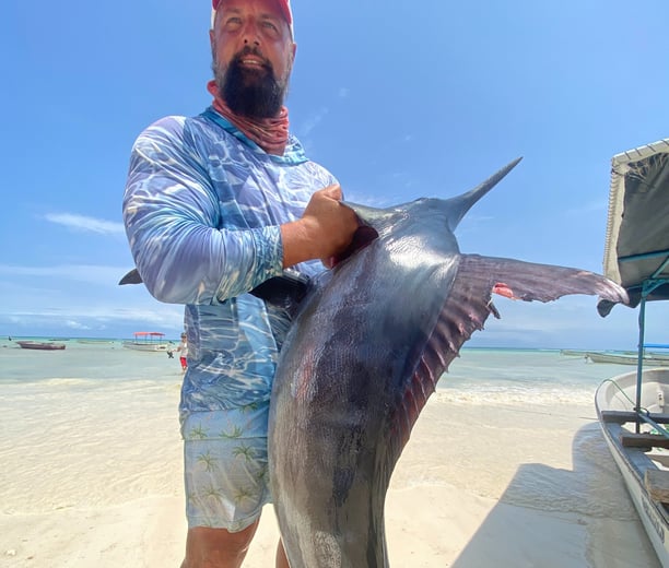 Angler with a black marlin caught on a Zanzibar Catamaran Fishing Charter