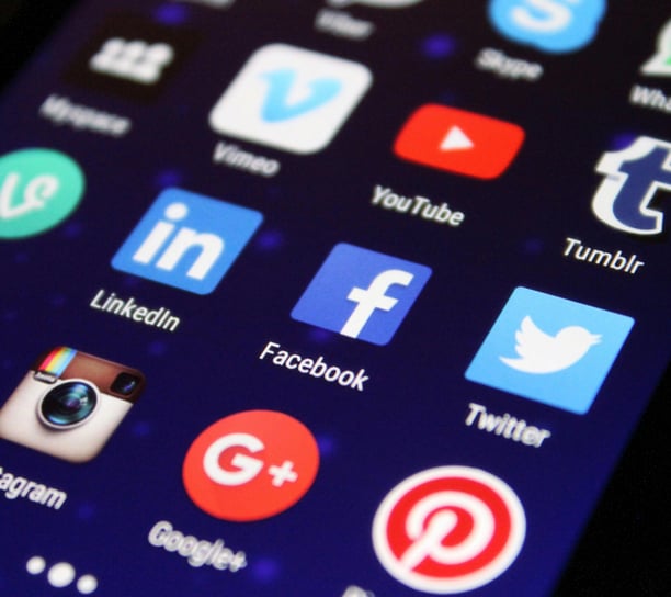 Display of popular social media app icons on a phone, representing social media management and digit