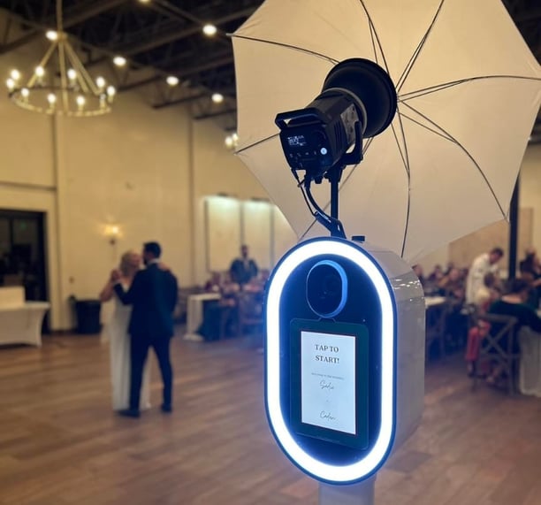 a photobooth camera flasher with a white umbrella and a white umbrella