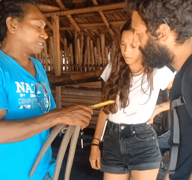 a man and woman standing in a hut with a hosel