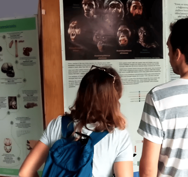 a man and woman standing in front of a poster board