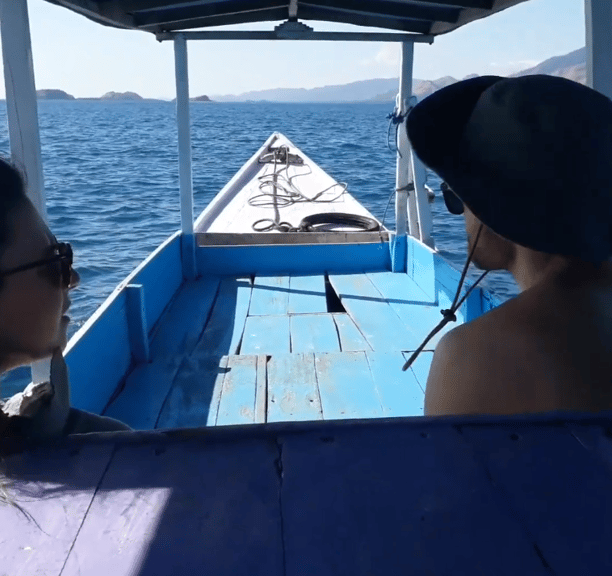 two people are sitting on a boat in the ocean