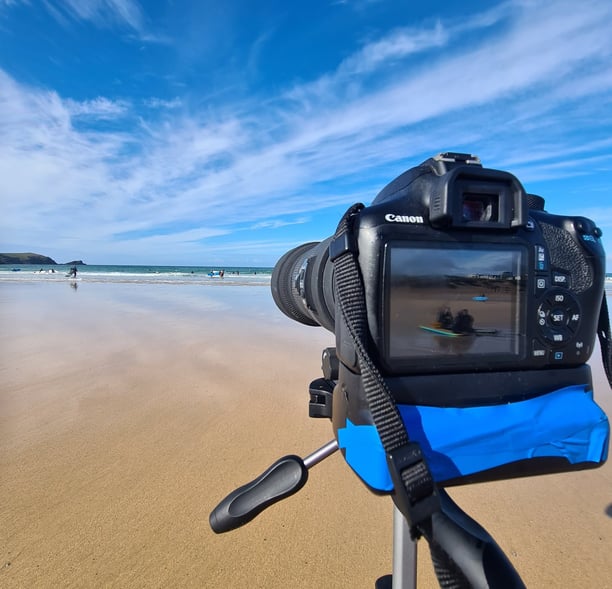 A Canon DSLR camera on a tripod at the beach for video analysis session