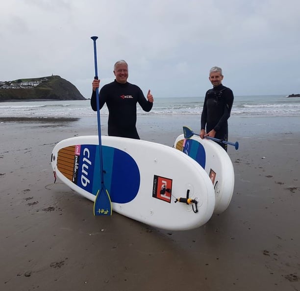 Derek 'The Weatherman' Brockway wituh paddle boards on Borth Beach.