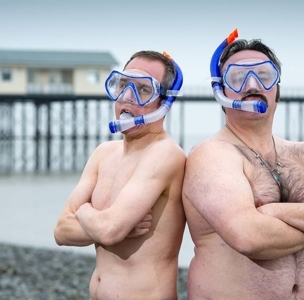 The Unexplainers posing in swimming trunks, weaking masks and snorkels