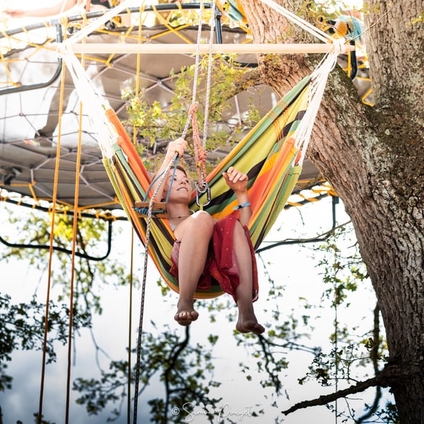 Jeunes femmes souriante dans une chaise suspendue
