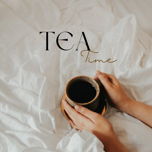 a person holding a cup of coffee in bed
